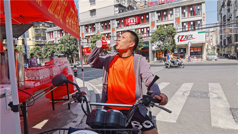 往来的户外工作者拿起冰水一饮而尽。人民网 胡雨松摄