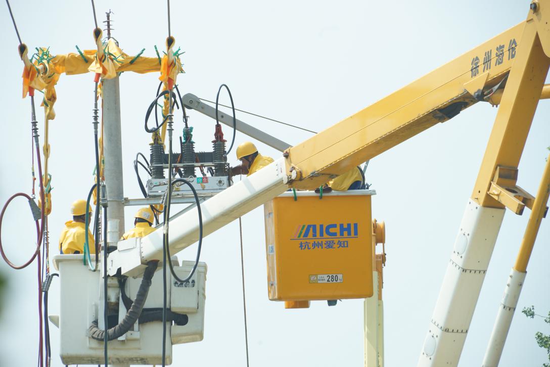 電力員工正在冒高溫進行供電設施安裝作業。馮厚慈攝