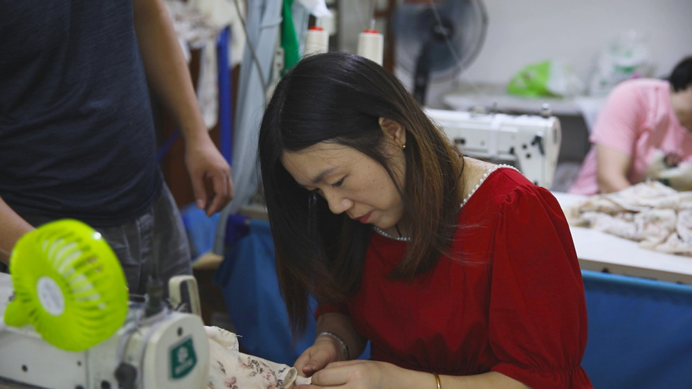 正在家楼下服装厂里工作的郭金妹。桐城市委宣传部供图