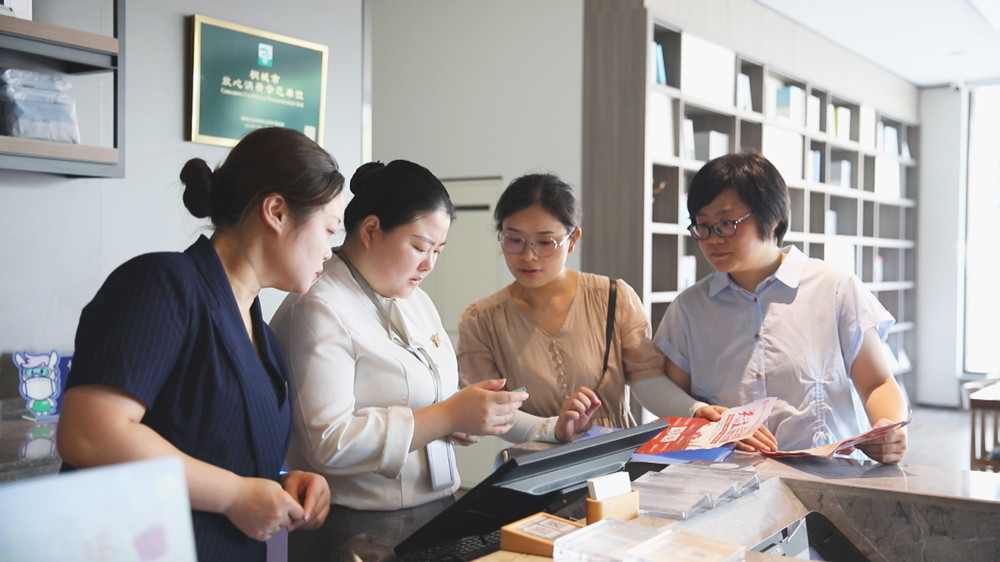 龙眠街道盛唐社区工作人员正在某实体店里推广“三公里”就业圈APP。桐城市委宣传部供图