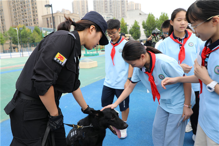 孩子们在特警队员的协助和保护下和警犬进行互动。 宋斌 摄