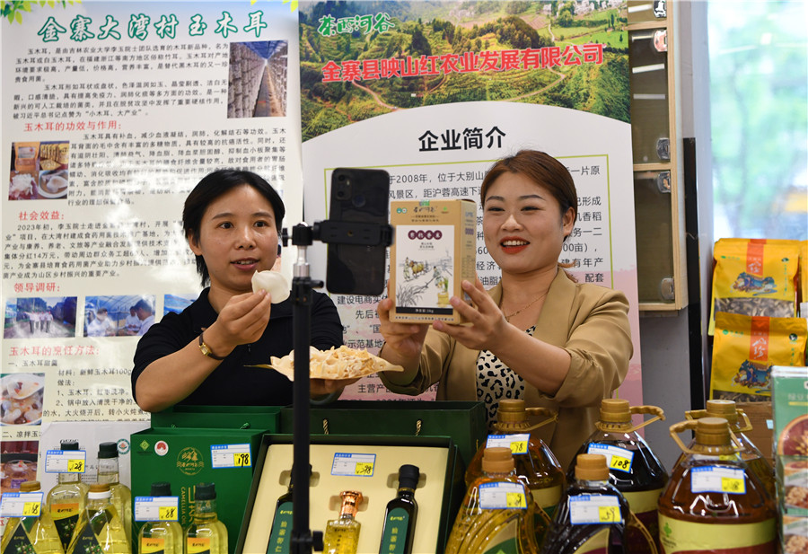 金寨縣二名農民專業合作社的社員在供銷大集上直播介紹大別山區農特產品。陳力攝