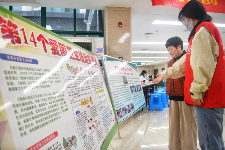 志愿者向群众普及爱国卫生知识。秦龙供图