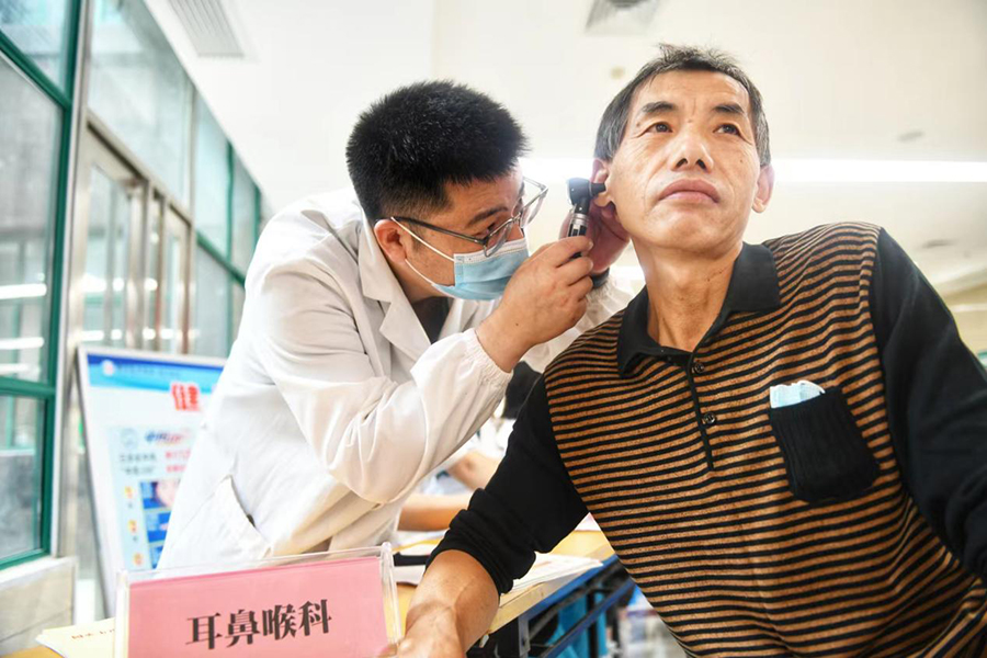 医生使用电子耳镜为群众检查耳道。秦龙供图