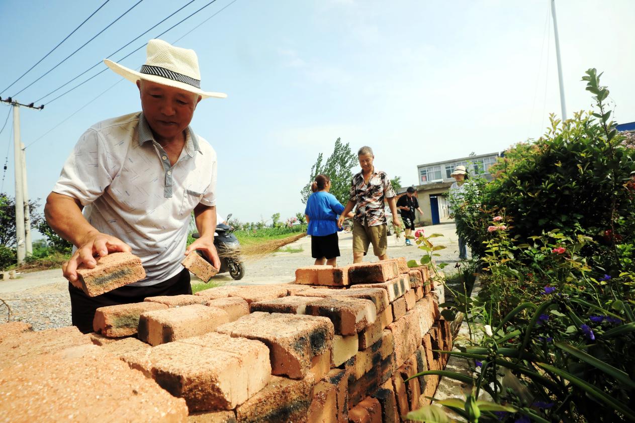 濉溪县双堆集镇祝庙村群众在整理码放门前屋后杂物。范胜明摄