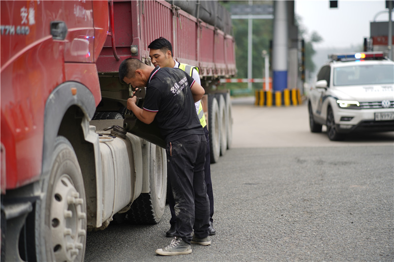 1六安北中心古碑收费站收费员毕伟帮助货车师傅一起给车辆加油。