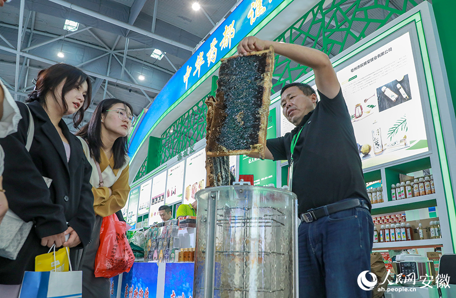 参展商现场展示蜂蜜提取。人民网记者 陶涛摄