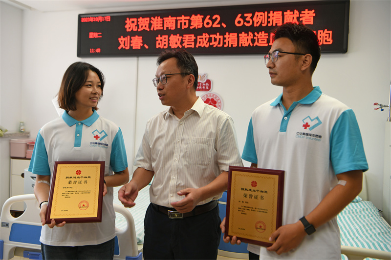 安徽省紅十字會為淮南師范學院兩名大四學生劉春（右一）、胡敏君（左一）頒發捐獻造血干細胞榮譽証書。陳彬攝