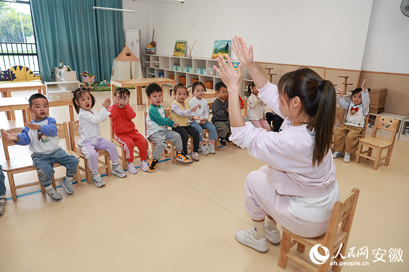 马鞍山玖璋台幼儿园，托班小朋友在老师带领下做游戏。人民网记者 张俊摄