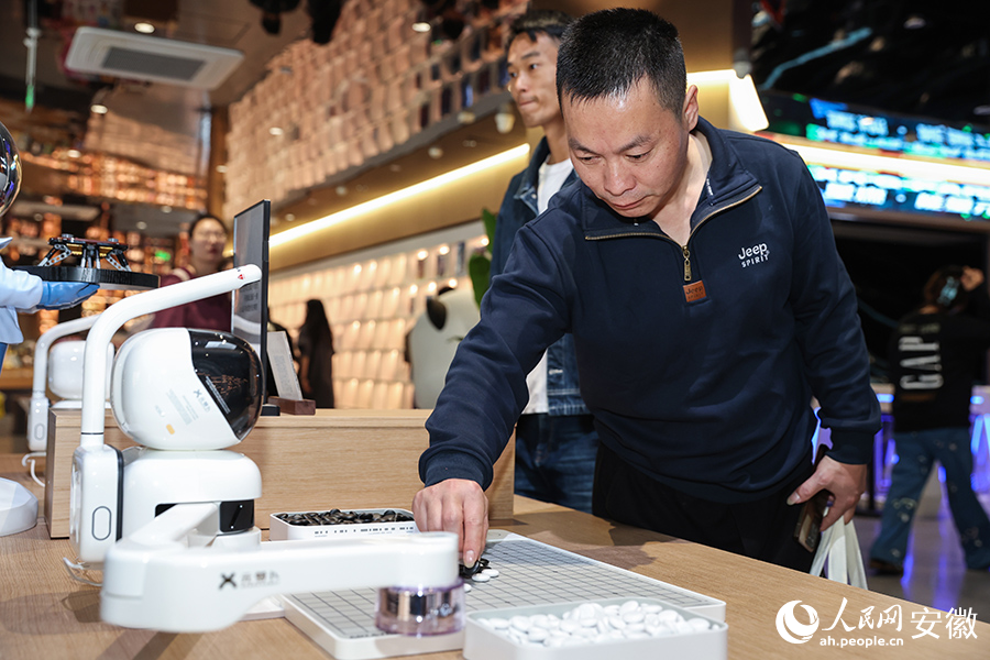 合肥元·书局，读者与AI机器人下棋。人民网记者 张俊摄