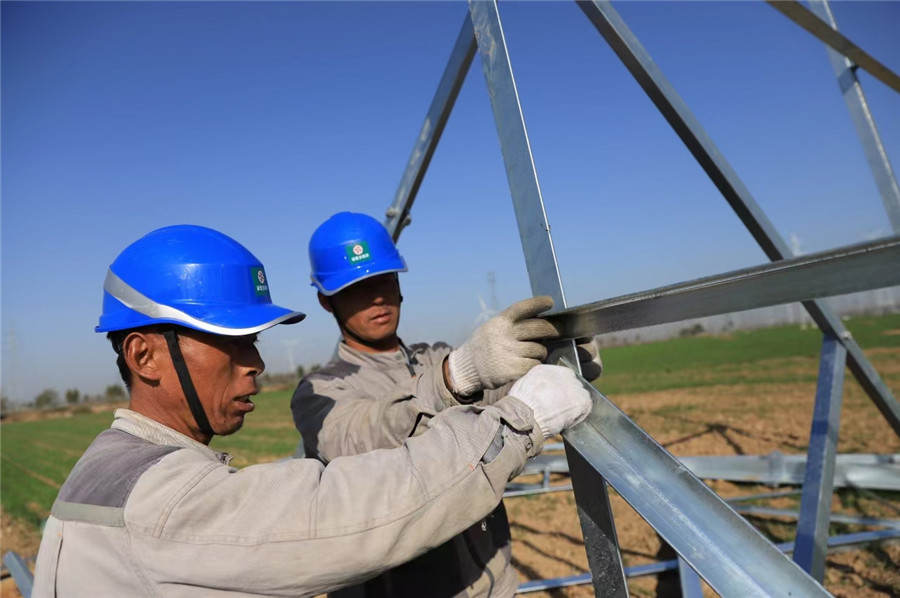 電力施工人員正在組裝鐵塔。李飛攝