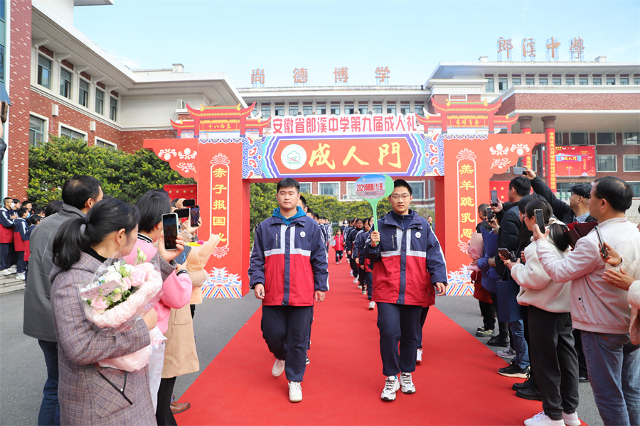 高三学子迈着激动的步伐从“成人门”走过。