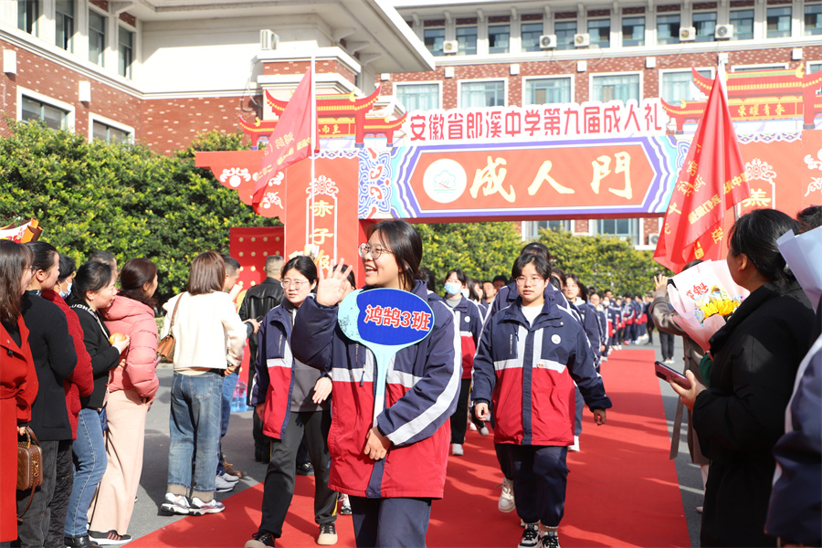 高三学子迈着激动的步伐从“成人门”走过。