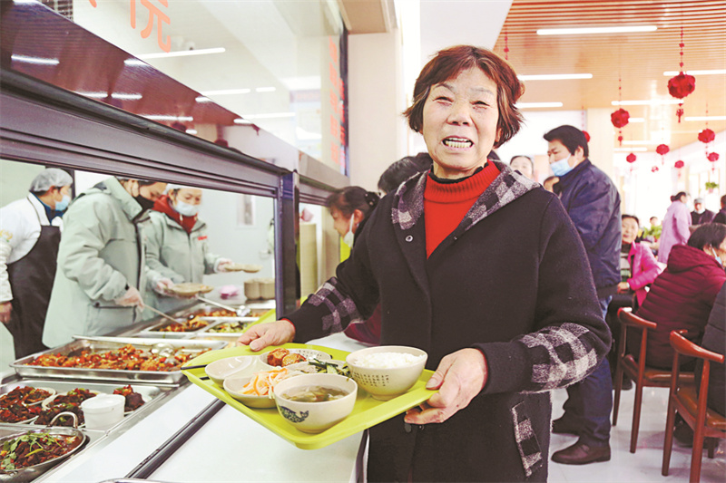 馬鞍山市雨山區向山鎮老年食堂就餐居民展示自己的午餐。