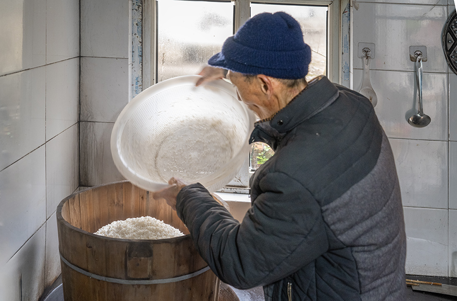 將米舀進熱氣騰騰的木甑中用旺火蒸。張余才攝