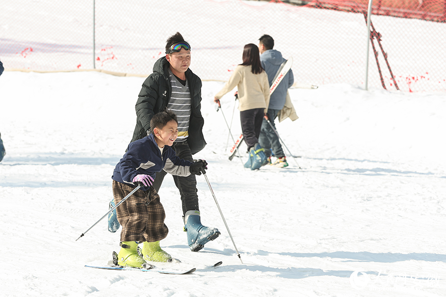 安徽岳西,家长陪同孩子在滑雪场同享冬趣。人民网记者 张俊摄