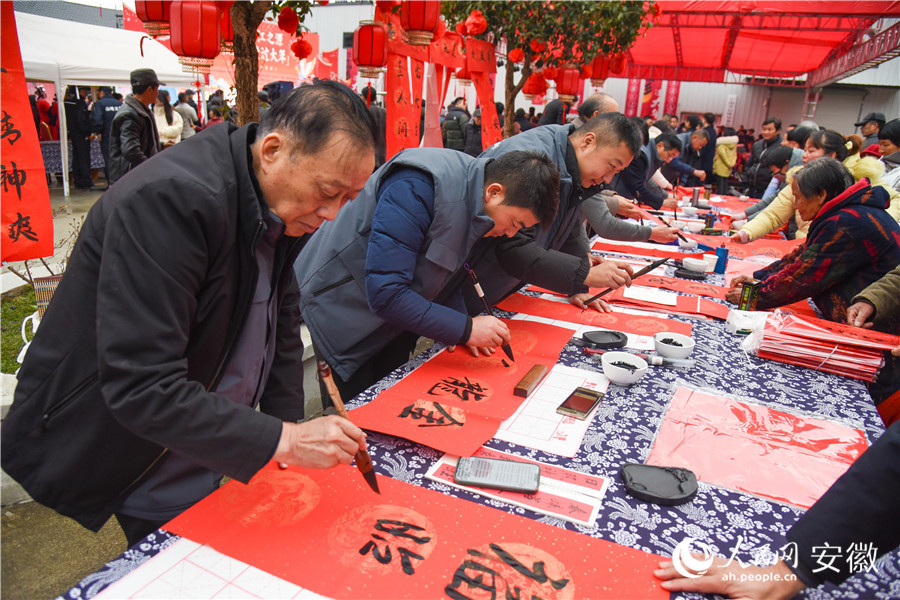 書法藝術家現場為村民寫春聯。人民網記者 李希蒙攝