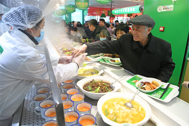 寿县寿春镇宾阳社区老人在助餐点享受美食。陈彬摄