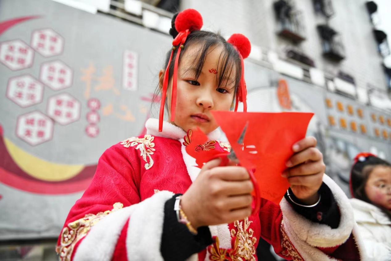 全神貫注剪紙的小女孩。秦龍供圖