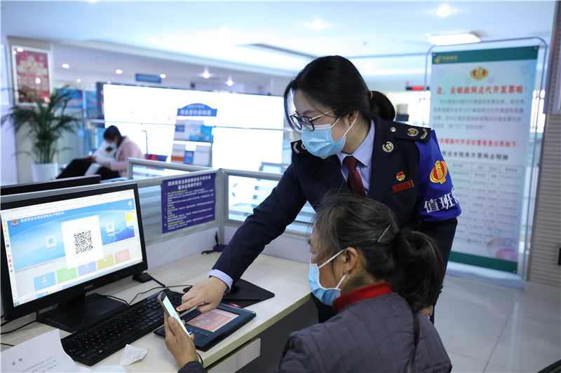 税务人员辅导纳税人业务“掌上办”。