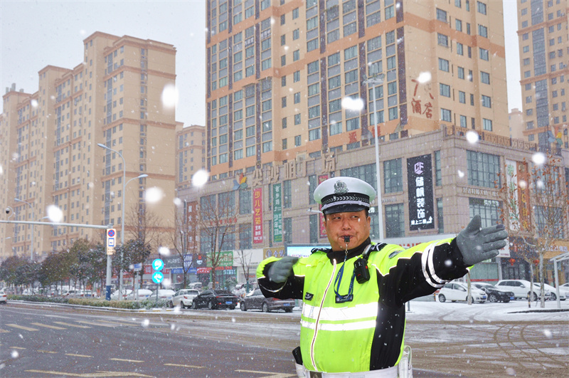 碭山縣公安局交警大隊城區中隊御都星城崗點的交警冒著嚴寒在雪中執勤，指揮車輛通行，及時疏導交通，成為一道美麗的雪“警”。張廣星攝