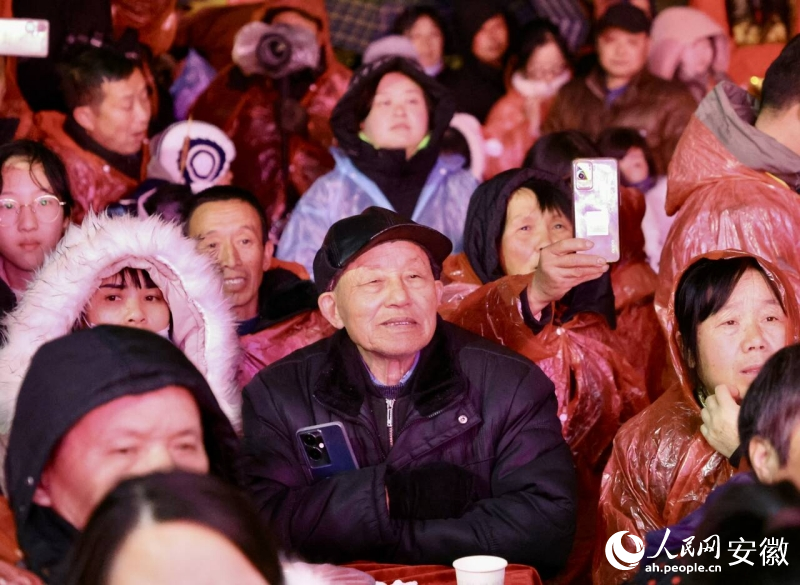 穿著雨披也不影響看“村晚”的興致。人民網記者 陶濤