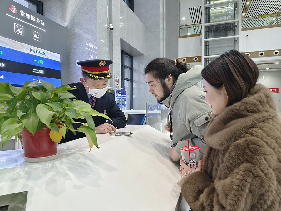 車站雷鋒服務台工作人員熱情幫助旅客解決出行困難。宿州火車站供圖