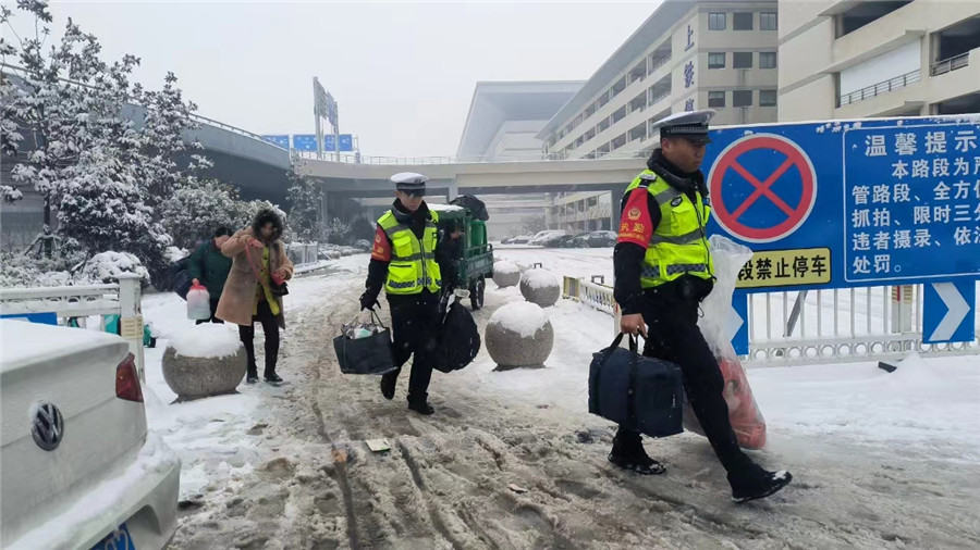 帮助旅客提行李。阜阳西站派出所供图