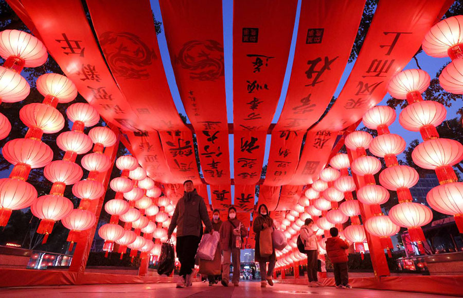 2月8日傍晚，旅客从合肥火车站广场的红灯笼长廊穿过。解琛摄