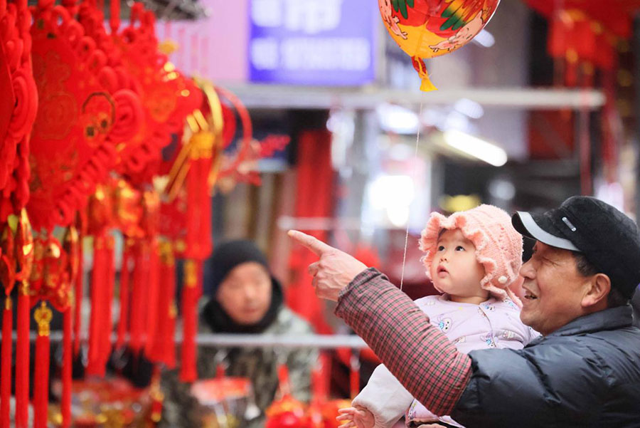 2月8日，一对爷孙在合肥长江批发市场内选购新年饰件。解琛摄