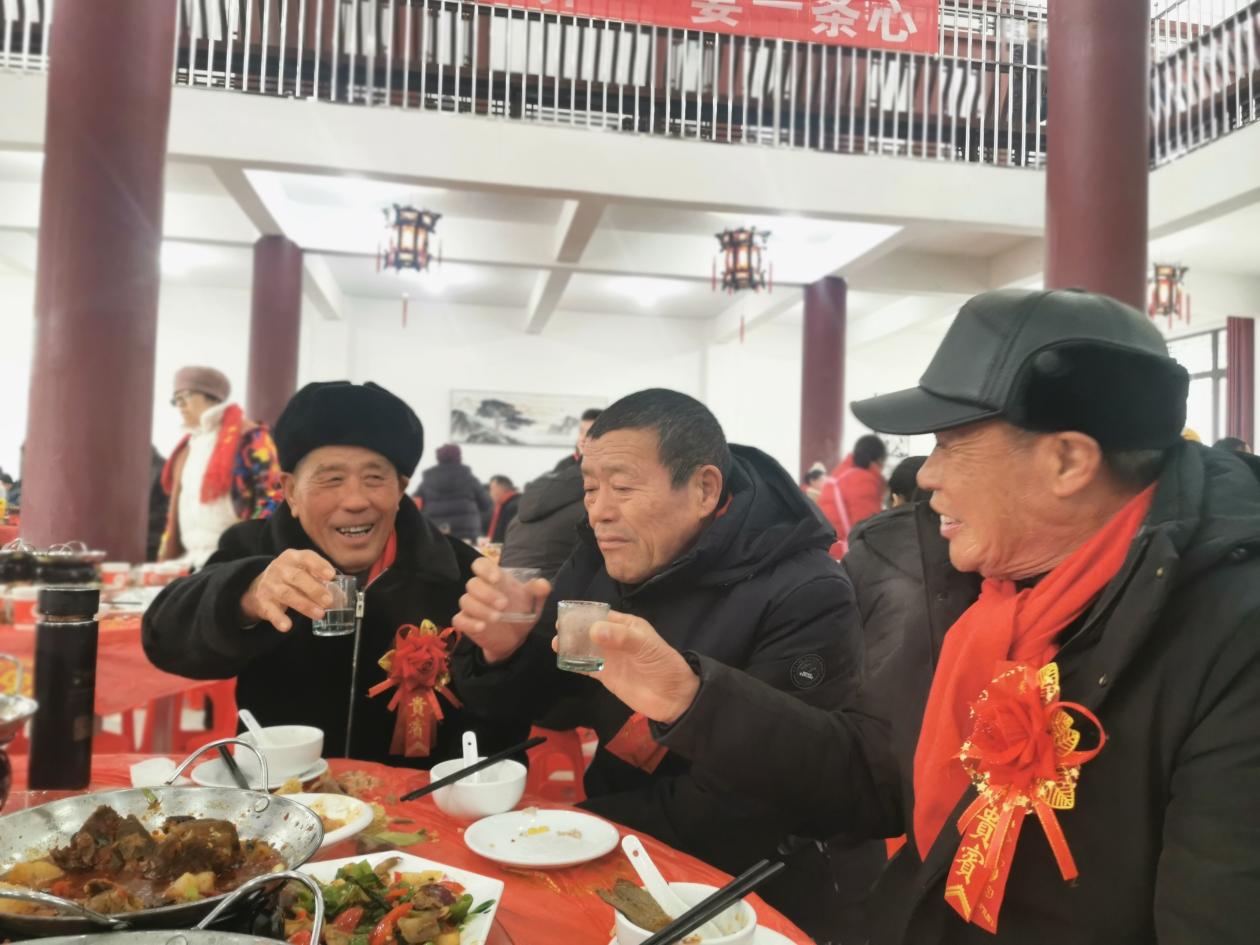 村民们开心地吃村宴。丁满莲供图