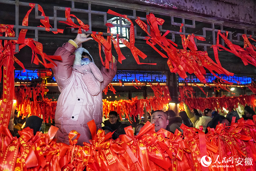 市民在太平桥上系红绳祈福，感受节日氛围。人民网记者 陈若天摄