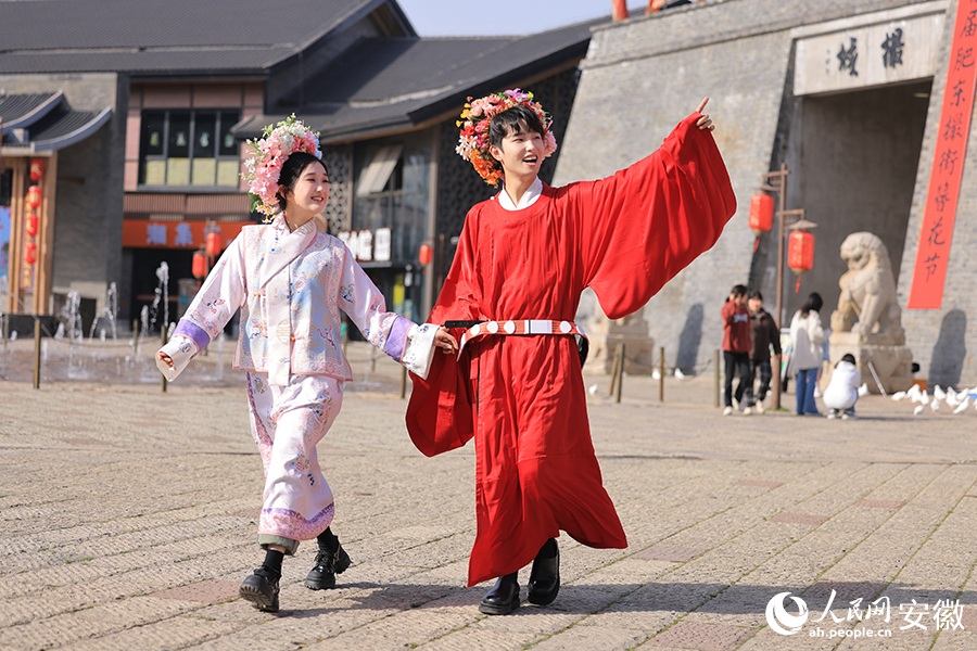 頭戴簪花的游客在撮街游玩。人民網記者 王曉飛攝