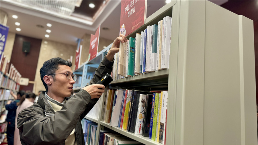 参会人员现采书籍。 人民网 吕欢欢摄