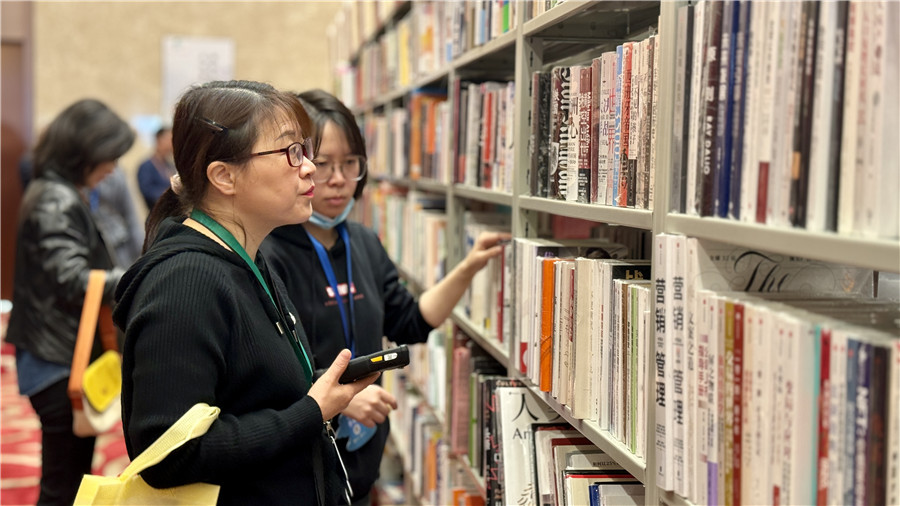 参会人员现采书籍。 人民网 吕欢欢摄