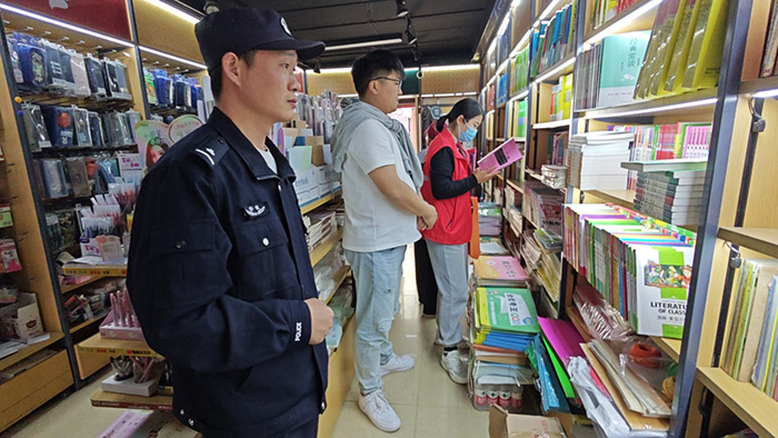 徐楊社區工作人員和民警對校園周邊出版物進行檢查。王宇翔供圖