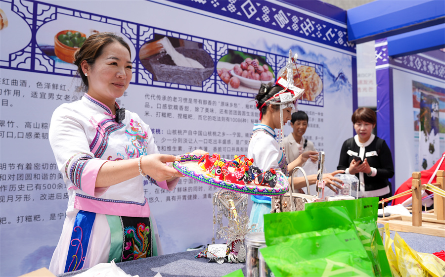 展台上，畲族姑娘正在向顾客售卖特色文创产品。人民网记者  王锐摄