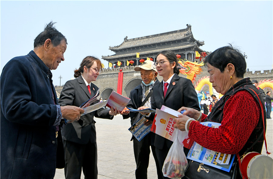 法院干警在寿县古城农历三月十五传统庙会现场，向群众宣传普及民法典、反电诈、扫黑除恶等法律法规。陈彬摄