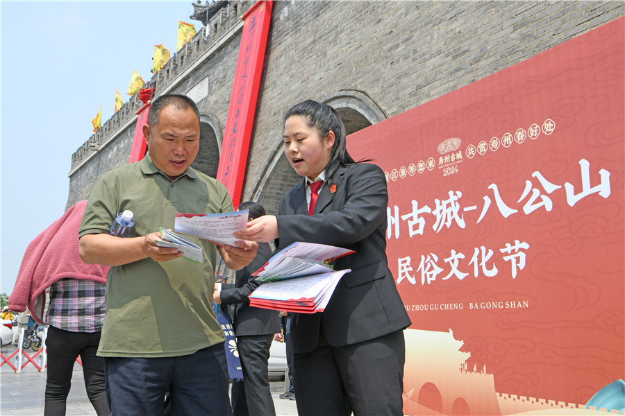 法院干警在寿县古城农历三月十五传统庙会现场，向群众宣传普及民法典、反电诈、扫黑除恶等法律法规。陈彬摄