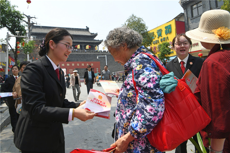 法院干警在寿县古城农历三月十五传统庙会现场，向群众宣传普及民法典、反电诈、扫黑除恶等法律法规。陈彬摄