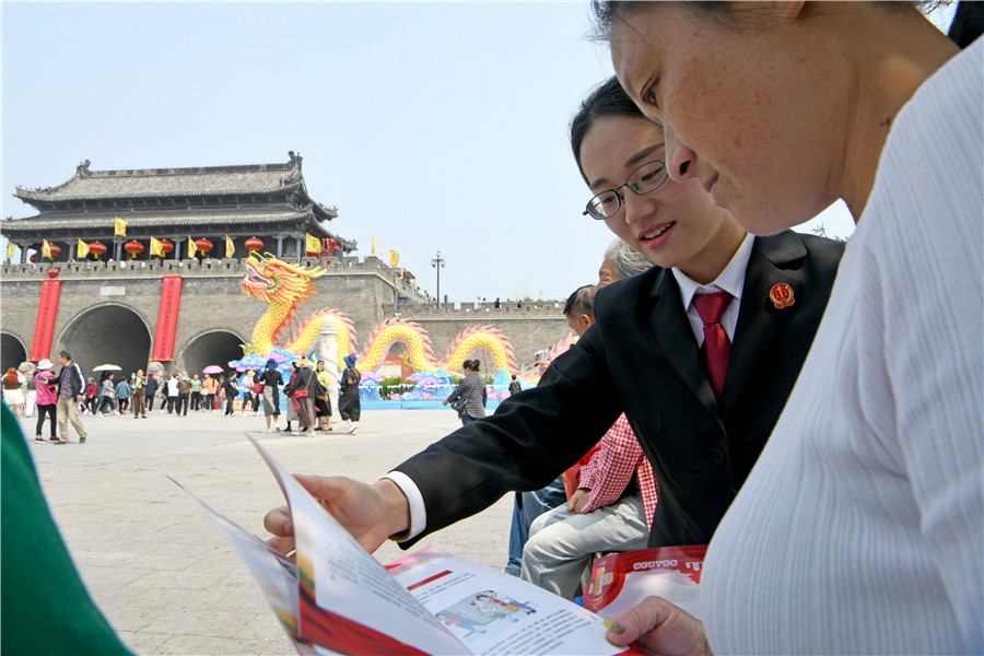 法院干警在寿县古城农历三月十五传统庙会现场，向群众宣传普及民法典、反电诈、扫黑除恶等法律法规。陈彬摄