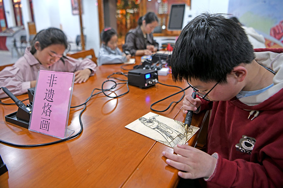 2024年5月5日，安徽省淮南市小朋友在淮南人民公園下沉廣場1952文化旅游街區體驗非遺烙畫。