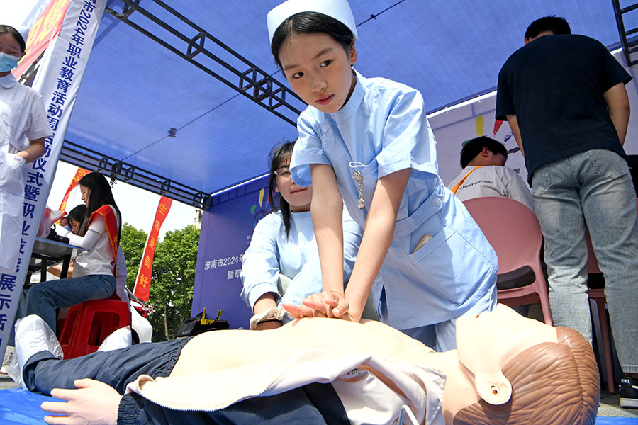 安徽省淮南衛生學校學生在淮南市2024年職業教育活動周現場展示急救技能。