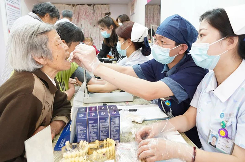 医务志愿者为居民免费检查口腔。