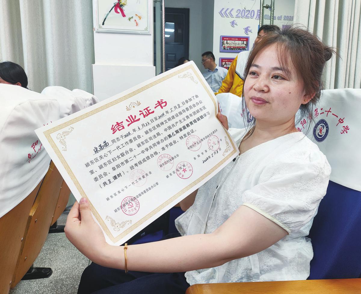 一家长领取结业证书。高红摄