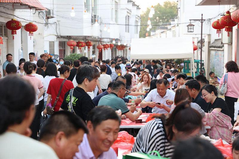 游客在昭关古街品尝龙虾宴。吴渊 摄