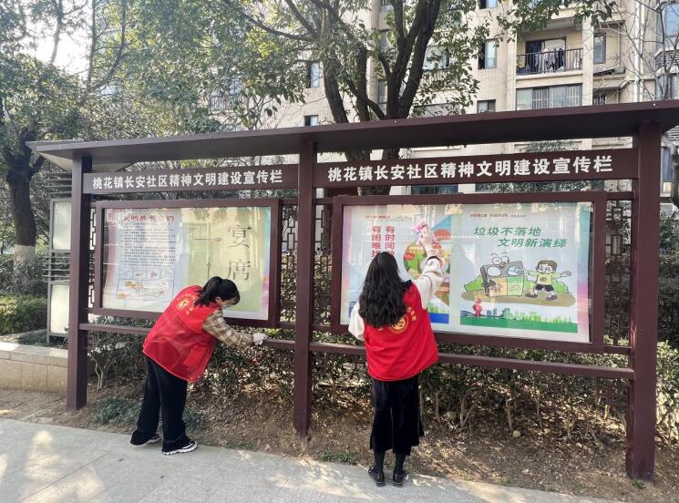 志愿者正在清理小区精神文明建设宣传栏。台靓摄
