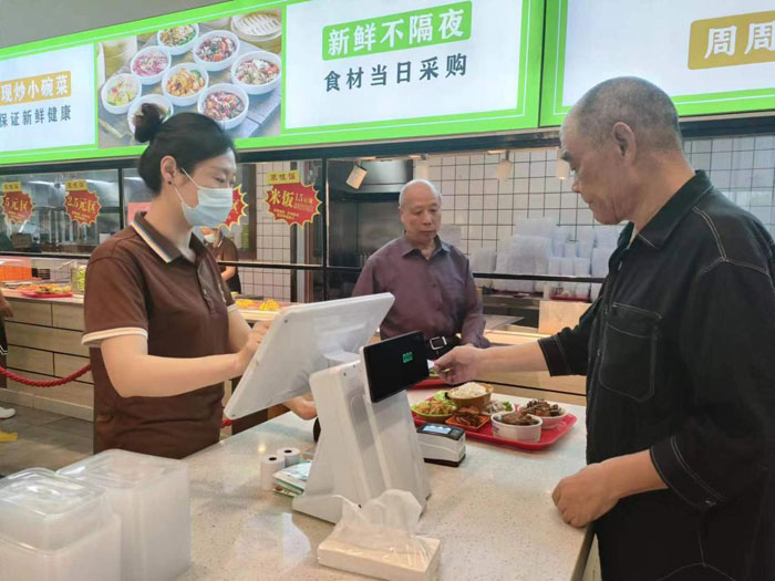 老年居民在銅陵某社區食堂使用助餐服務系統就餐（取餐）。工行安徽省分行供圖