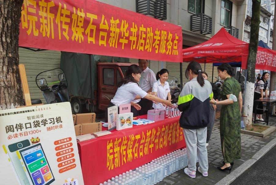 池州石台新华书店工作人员在助考点为考生和家长提供服务。