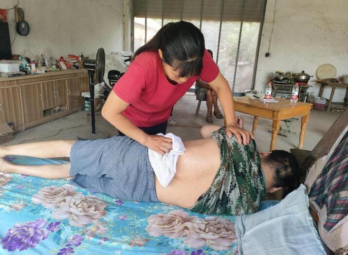 辛敏每天给卧床的丈夫擦洗身体。县委宣传部供图。